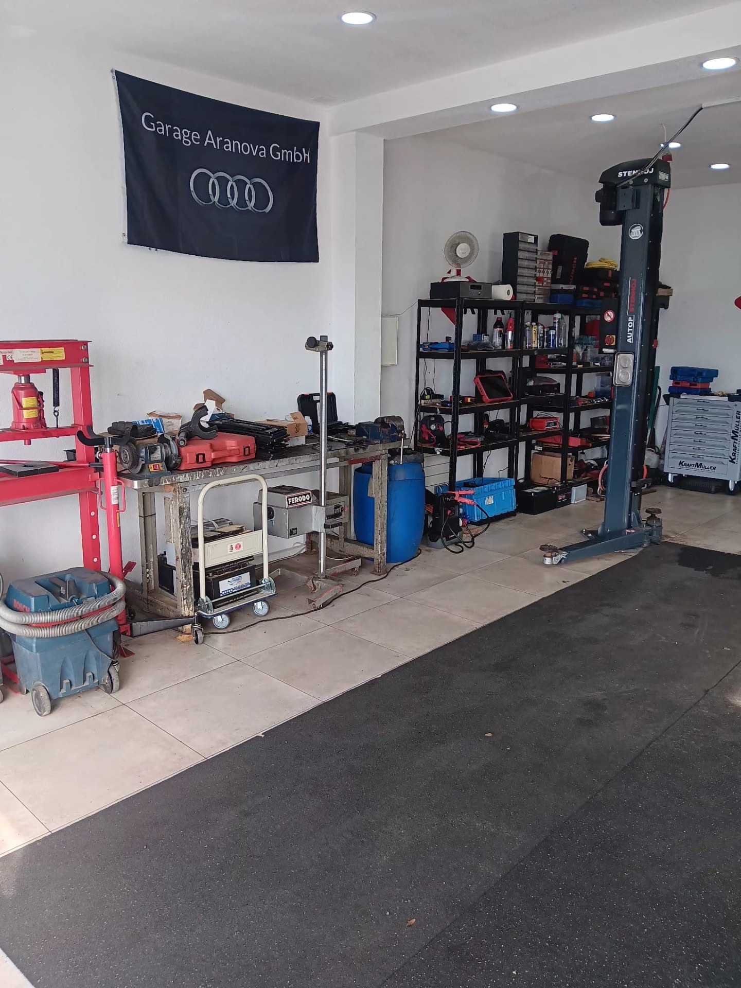 Werkstatt mit Hebebühne und Audi Flagge